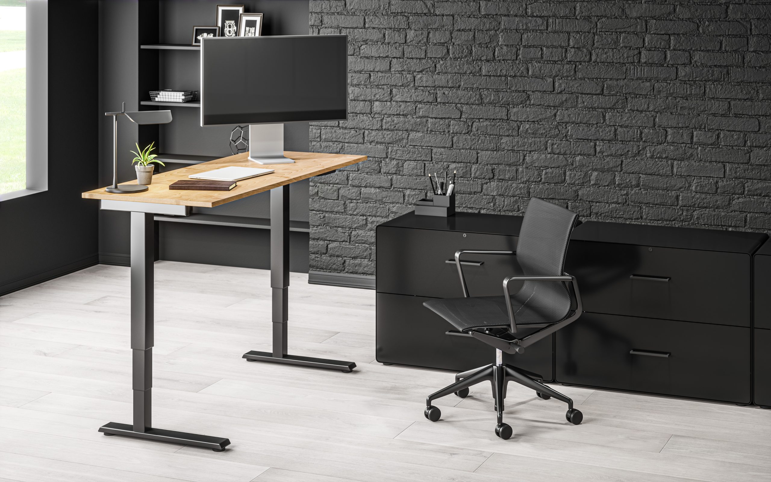 Standing desk with a wood work surface in a dark architectural office.