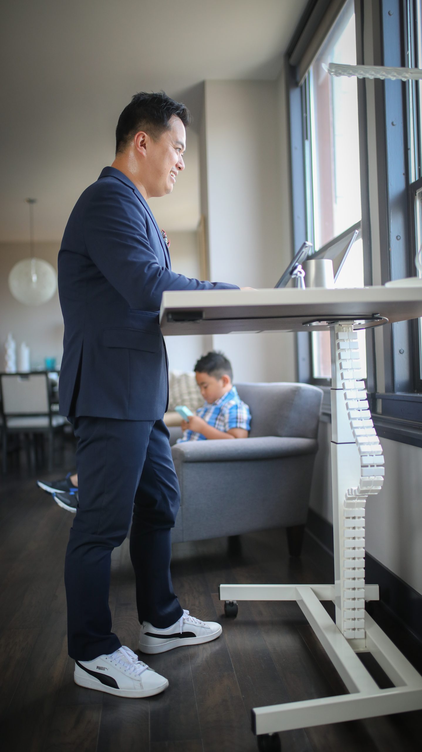 Person working at a white standing desk with the cable-management chain visible