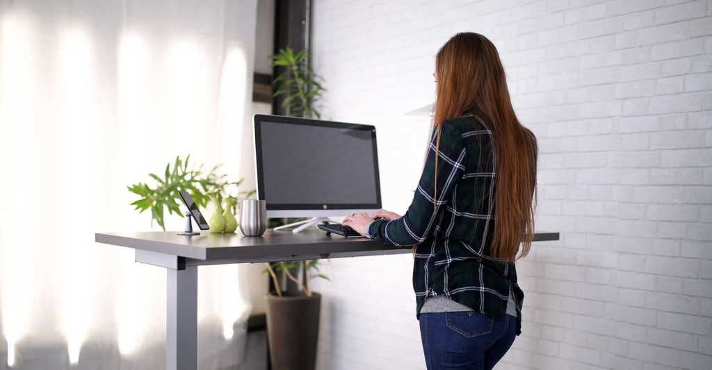 Person working while standing at a height-adjustable desk
