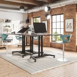 Lüften standing desks arranged in a bright brick-walled office