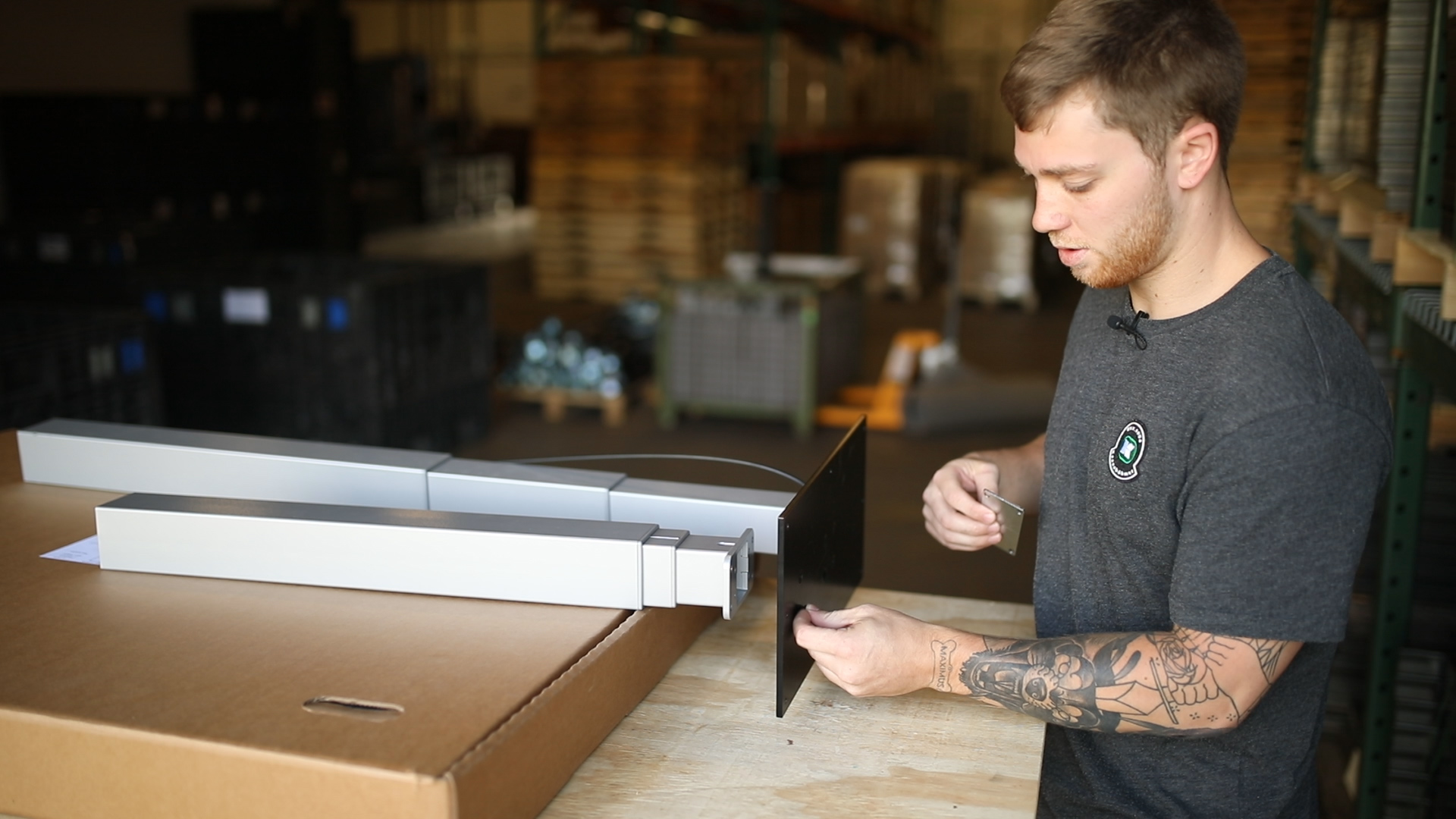 Technician assembling a silver Lüften standing desk frame