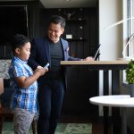Adult and child beside a Nimbus standing desk in a home workspace