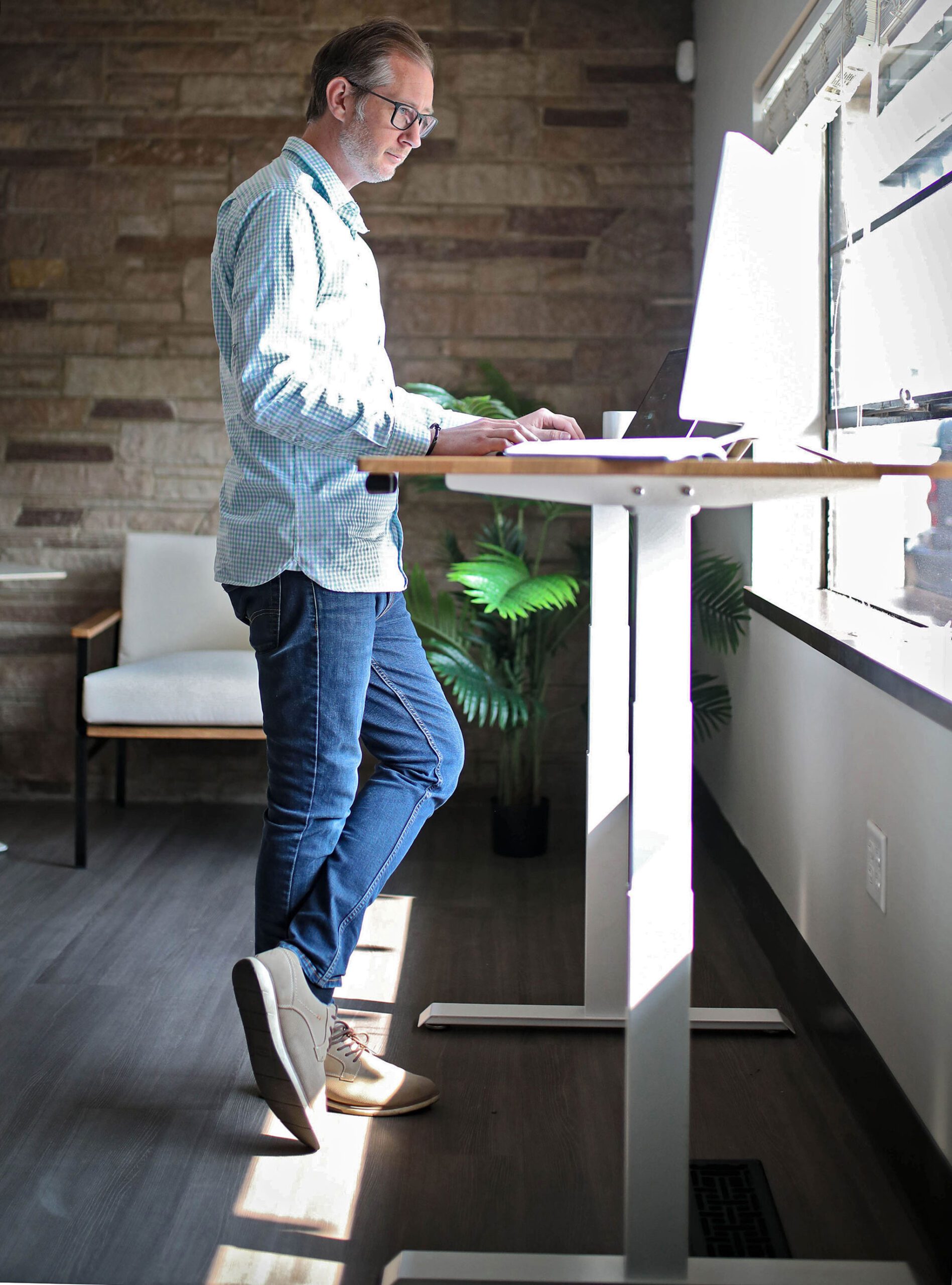 Person standing and working at a white Recken electric desk